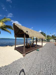 a straw hut on a beach with the ocean at Le Rainoa - Beach House in Taputapuapea
