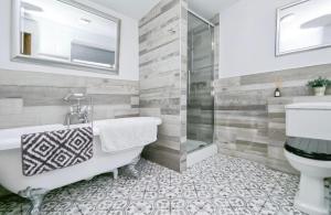 a bathroom with a tub and a sink and a toilet at The Blue Dolphin with Panoramic Sea Views in Tythegston