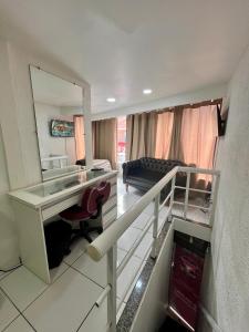 a living room with a desk and a mirror at Loft Aloha in Cabo Frio