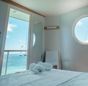 a bedroom with a bed with a view of the ocean at Lagoon Lodge Caraïbes -Lodge flottant sur lagon avec vue mer in Saint-François