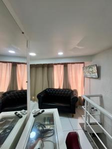 a living room with a couch and a table at Loft Aloha in Cabo Frio