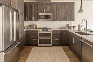 a kitchen with wooden cabinets and stainless steel appliances at Mountain Lake Condo Unit 402D in Big Sky