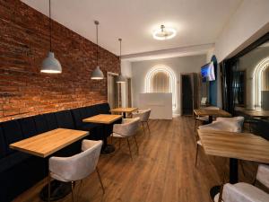 a restaurant with tables and chairs and a brick wall at Pensiunea Brici Junior in Cluj-Napoca