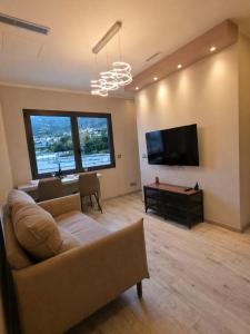 a living room with a couch and a flat screen tv at 4 Seasons Apartment in Taverne