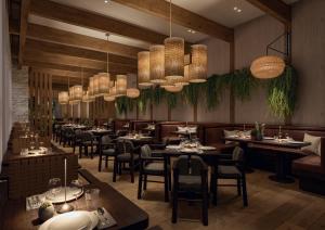 a restaurant with tables and chairs and chandeliers at 1 Hotel Austin in Austin