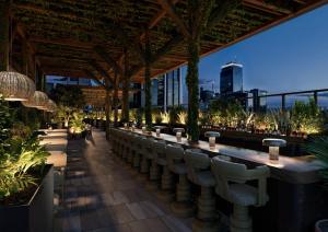 a bar with chairs and a view of the city at 1 Hotel Austin in Austin