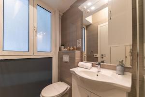 a bathroom with a sink and a toilet and a mirror at CentRooms Kovac in Zadar
