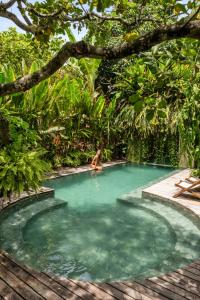 a woman in a swimming pool in a jungle at Pousada Nativa in Caraíva