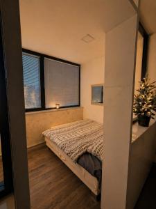 a bedroom with a bed and two windows at Ninche's Penthouse - free private parking in Pljevlja