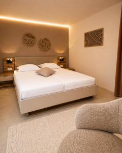 a bedroom with a large white bed and a couch at Sindelfingen Apartments in Sindelfingen