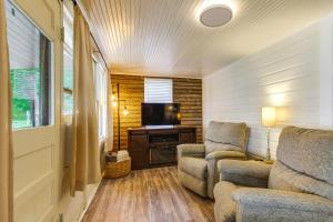 a living room with two chairs and a television at Lakefront Ozarks Home w/ Private Dock & Patio! in Roach