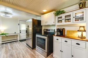 a kitchen with white cabinets and a black refrigerator at Lakefront Ozarks Home w/ Private Dock & Patio! in Roach