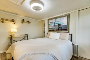 a bedroom with a large white bed with a window at Lakefront Ozarks Home w/ Private Dock & Patio! in Roach