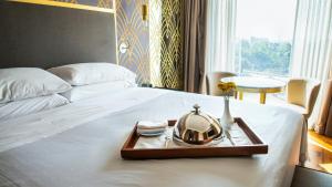 a tray with a clock on a bed at Grand Fiesta Americana Chapultepec in Mexico City