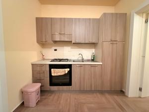 a kitchen with wooden cabinets and a sink and a stove at Il gelso in Bovalino Marina