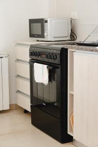 a black oven with a microwave on top of it at RGA Apartments in Río Grande
