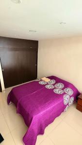 a large purple bed with a purple blanket on it at Aparta studio Zona Centro in Darién