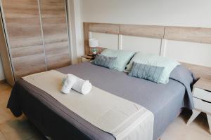 a bedroom with a large bed with towels on it at RGA Apartments in Río Grande +8 photos