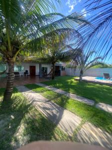 a view of a yard with palm trees at Casa para temporada Diversão e sossego PRÓXIMA A PRAIA in Rio das Ostras