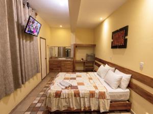 a small bedroom with a bed and a tv at Casa Nativa Iquitos in Iquitos