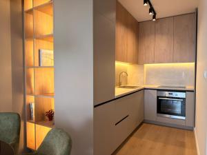 a kitchen with wooden cabinets and a sink and a stove at Marea Apartment in Bar