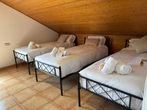 three beds in a room with wooden ceilings at Villa Playa Covelo in Pontevedra +42 photos