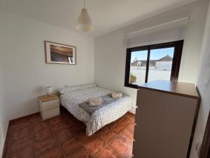 a small bedroom with a bed and a window at Ático luminoso con terraza privada in Sanlúcar de Barrameda