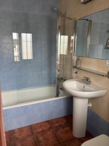 a bathroom with a sink and a toilet and a shower at Ático luminoso con terraza privada in Sanlúcar de Barrameda +14 photos