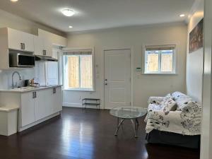 a kitchen and a living room with a couch and a table at Spacious 3 Bedroom Suite in Burnaby Free Parking, Full Kitchen, Near Transit in Burnaby