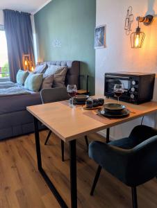 a living room with a table and two glasses of wine at MeLou Fewo Harzruhe Wellness in Bad Lauterberg