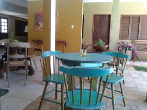 une table bleue et des chaises dans une pièce dans l'établissement Hospedaria Lua Raio de Sol, à Natal