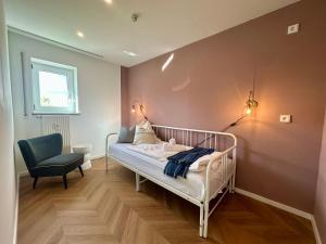 a bedroom with a bed and a chair in it at Moderne Apartments im Bayerischen Wald mit Bergblick, Balkon & großer Terrasse in Schöfweg
