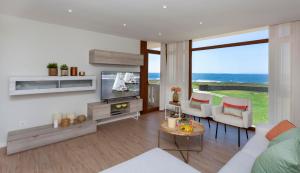 a living room with a couch and a tv at Casa do Seixo in Oia