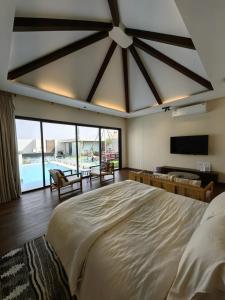 a large bedroom with a large bed and a tv at منتجع تربل فور - Triple Four Resort in Buraydah