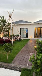 a garden with a wooden deck with a windmill at منتجع تربل فور - Triple Four Resort in Buraydah