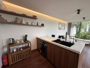 a kitchen with a sink and a washing machine at منتجع تربل فور - Triple Four Resort in Buraydah
