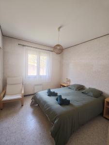 a bedroom with a large bed and a chair at Maison tout confort équipée Camargue in Saint-Gilles