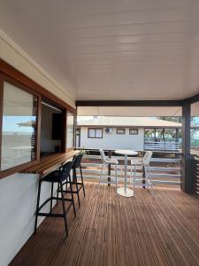a room with a table and chairs on a deck at Le TeRava - Beach House in Ataiti