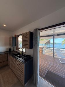 a kitchen with a view of the ocean from a balcony at Le TeRava - Beach House in Ataiti