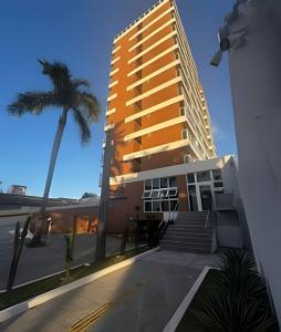 a tall building with a palm tree in front of it at 808 Vista para o Mar in Salvador