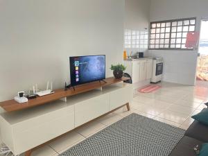 a living room with a flat screen tv on a counter at Aconchego 3 - Self Check-in in Presidente Prudente