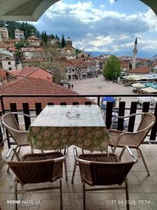 a table and chairs on a balcony with a view of a city at Apartments Mostrovi in Ohrid
