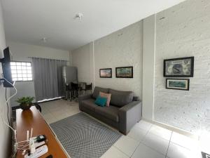 a living room with a couch and a table at Aconchego 3 - Self Check-in in Presidente Prudente