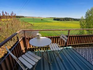 a table and chairs on a balcony with a view of a field at Gästehaus Mohr in Eberhardzell