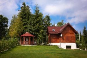 a wooden barn with a gazebo in a yard at Cabana Călățele in Călăţele