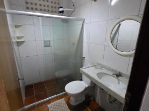 a bathroom with a toilet and a sink and a mirror at Pousada Nova Flor de Lotus Suites in Tamandaré +14 photos