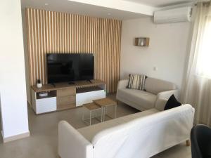 a living room with a couch and a flat screen tv at Casa Dulcelina Monte Gordo, Algarve, Portugal in Monte Gordo