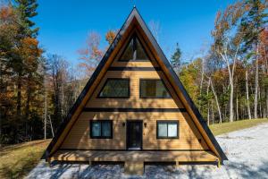 a frame cabin with a triangle roof in the woods at Green Mountain Yay Frame in Killington