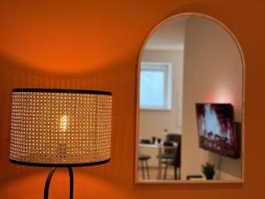 a living room with a lamp and a mirror at Cocon Terracotta - Netflix et Parking in Scheibenhard
