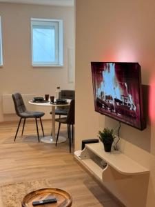a living room with a flat screen tv on a wall at Cocon Terracotta - Netflix et Parking in Scheibenhard